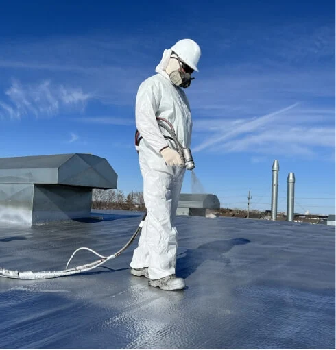Worker spraying roof