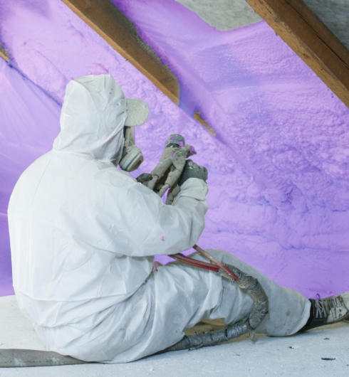 worker applying spray foam insulation