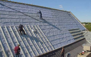 workers applying spray foam insulation to exterior roof